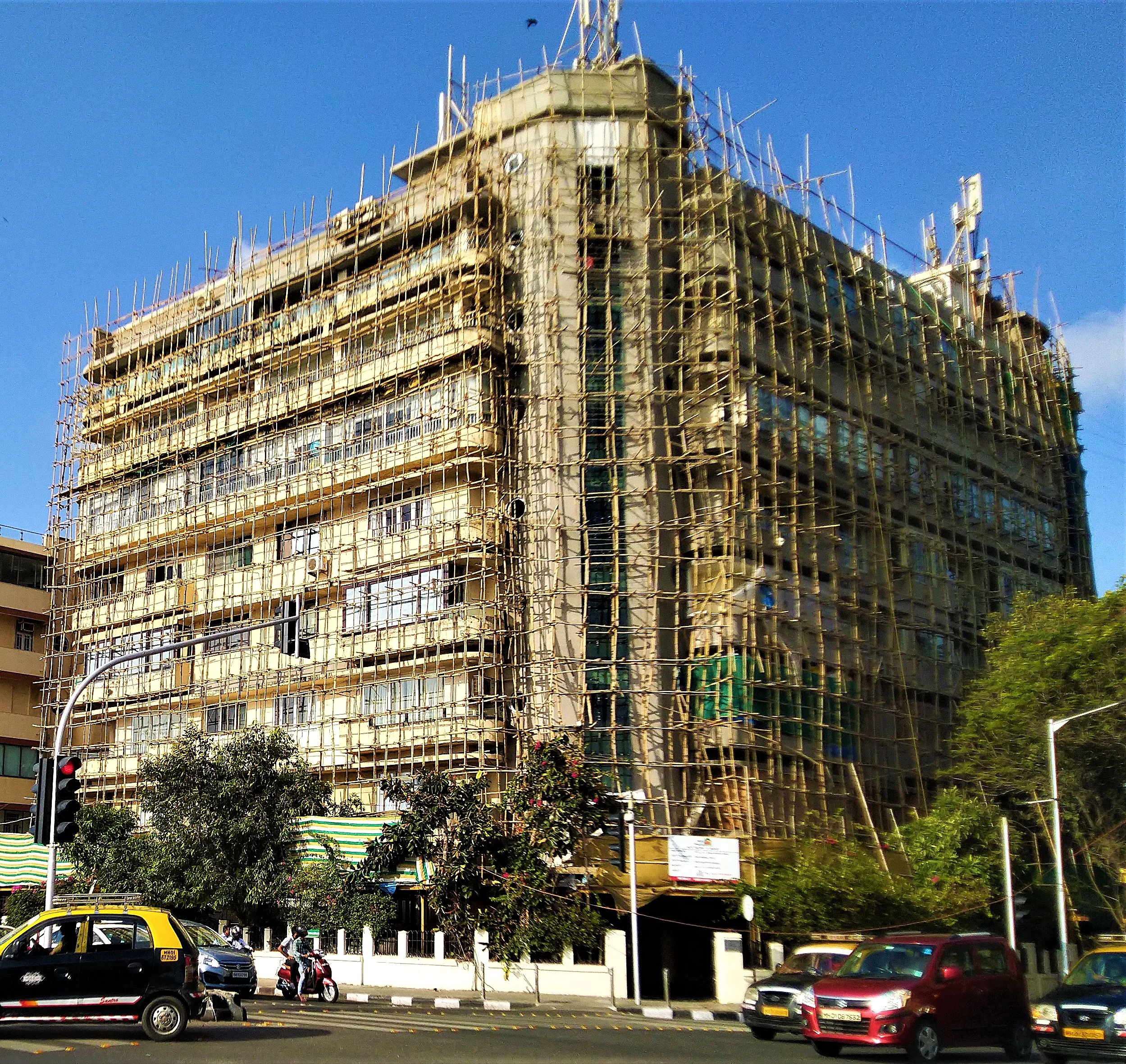 Older Mumbai building wrapped in bamboo scaffolding during renewal works